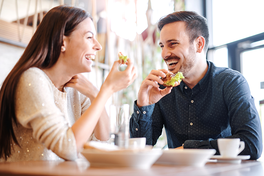 two people eating fast-food smiling